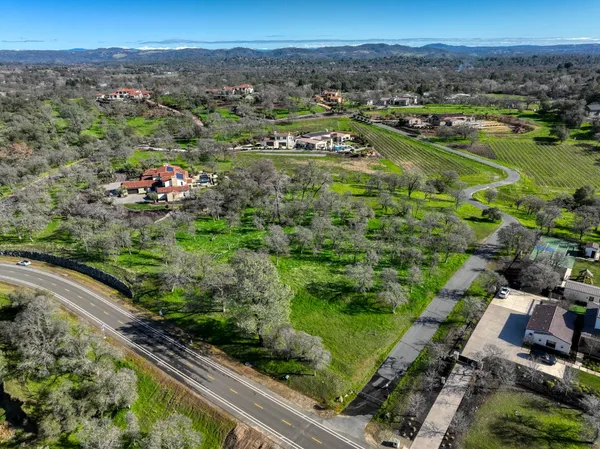 an aerial view of residential houses with outdoor space and trees