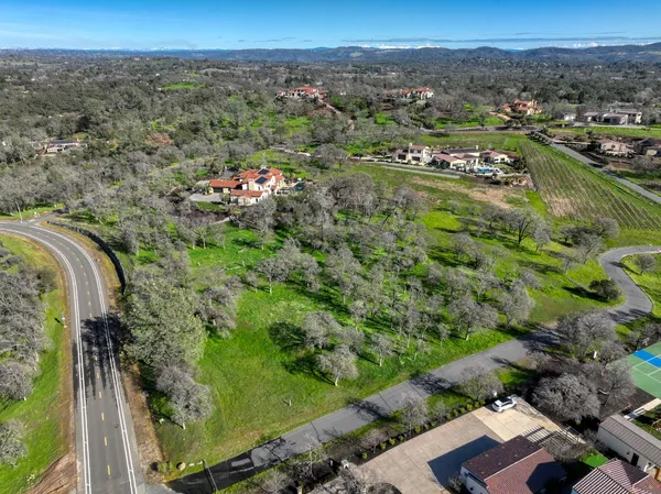 an aerial view of residential houses with outdoor space and trees