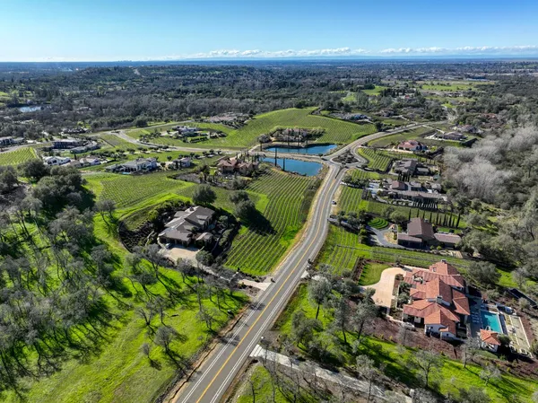 an aerial view of residential houses with outdoor space and trees