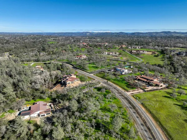 an aerial view of residential houses with outdoor space and trees