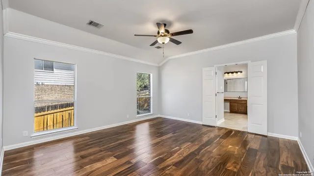 a view of empty room with wooden floor and ceiling fan