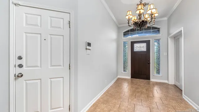 a view of a hallway with windows and chandelier