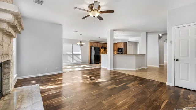 a view of a livingroom with wooden floor and a ceiling fan