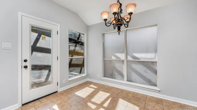 a view of a room that has a glass door and a chandelier
