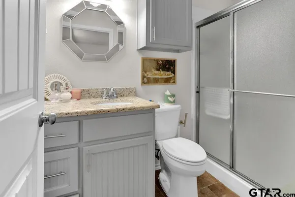 a bathroom with a toilet sink vanity and mirror