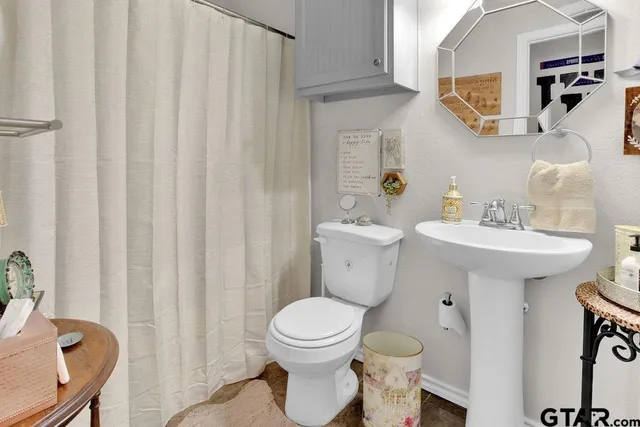 a bathroom with a toilet sink and mirror