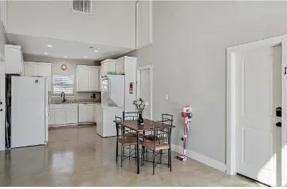 a kitchen with stainless steel appliances a refrigerator a table and chairs