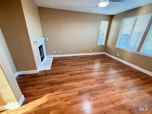 a view of kitchen with stainless steel appliances wooden floor and refrigerator