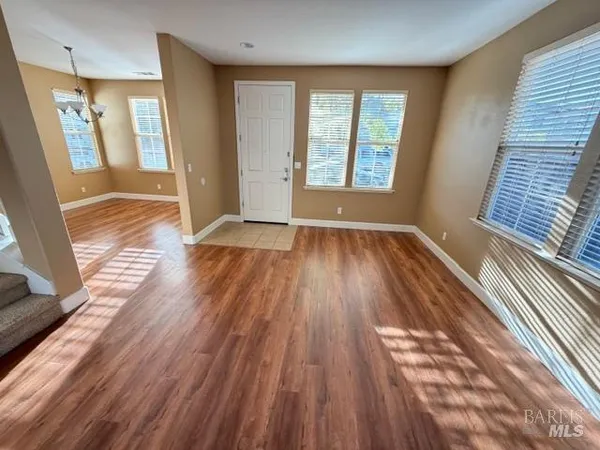 a view of a livingroom with wooden floor and staircase