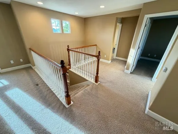 an empty room with a window and a chandelier fan