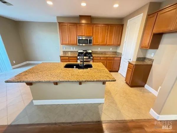 a kitchen with stainless steel appliances granite countertop a stove a sink and a refrigerator