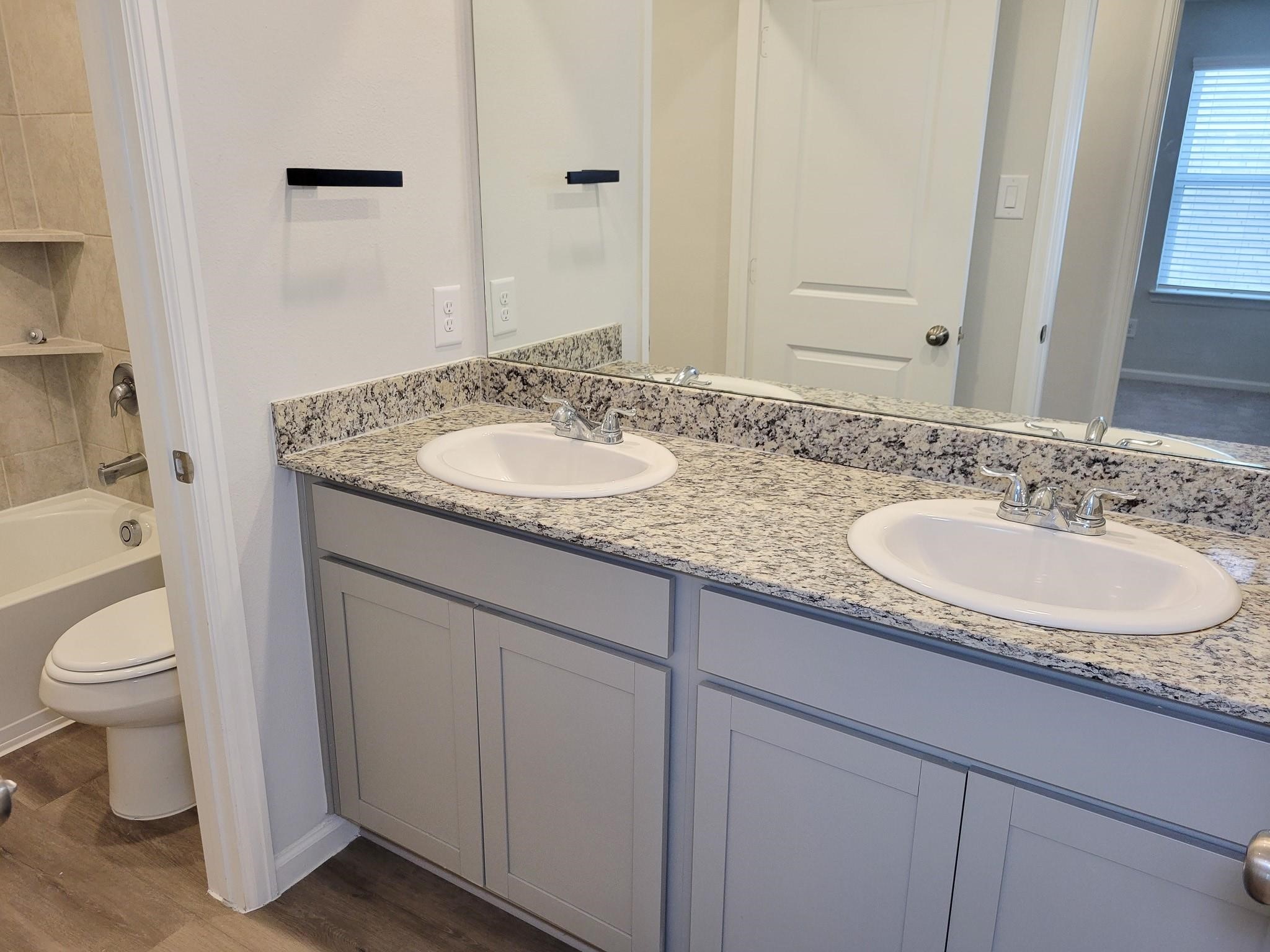 94 Valiant Ridge Trail Magnolia, TX 77354 - Photo 11 of 45 a bathroom with a granite countertop sink and a mirror