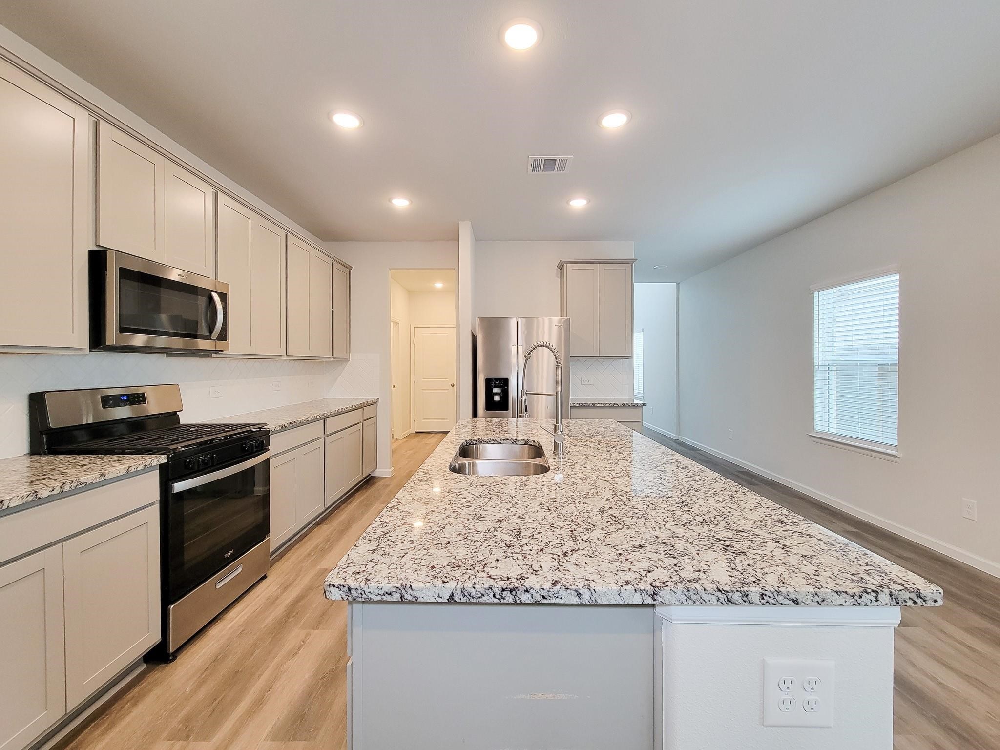 94 Valiant Ridge Trail Magnolia, TX 77354 - Photo 35 of 45 a kitchen with stainless steel appliances granite countertop a sink stove and microwave