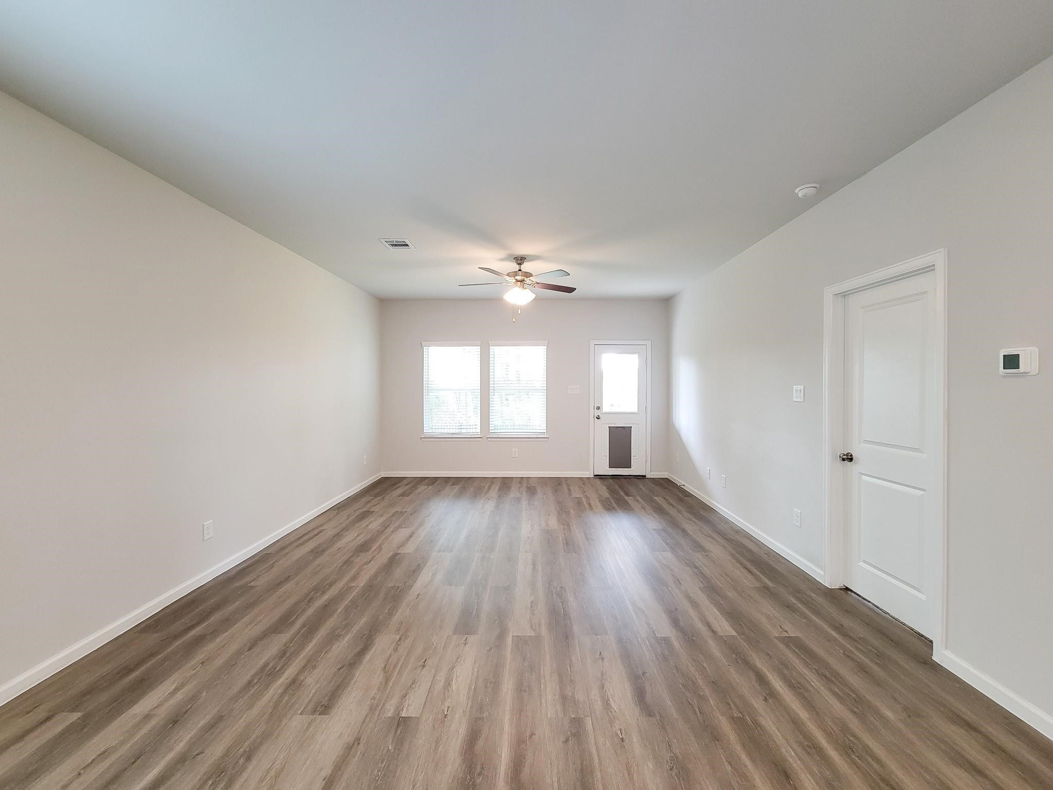 94 Valiant Ridge Trail Magnolia, TX 77354 - Photo 8 of 45 an empty room with wooden floor and windows