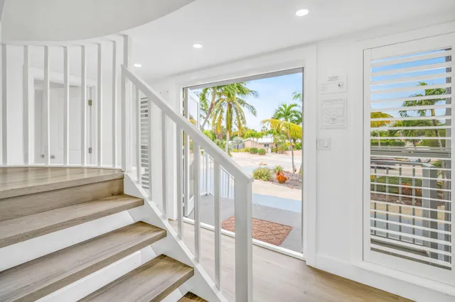 a view of a swimming pool with outdoor seating and trees in the background