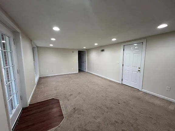 an empty room with wooden floor and entrance