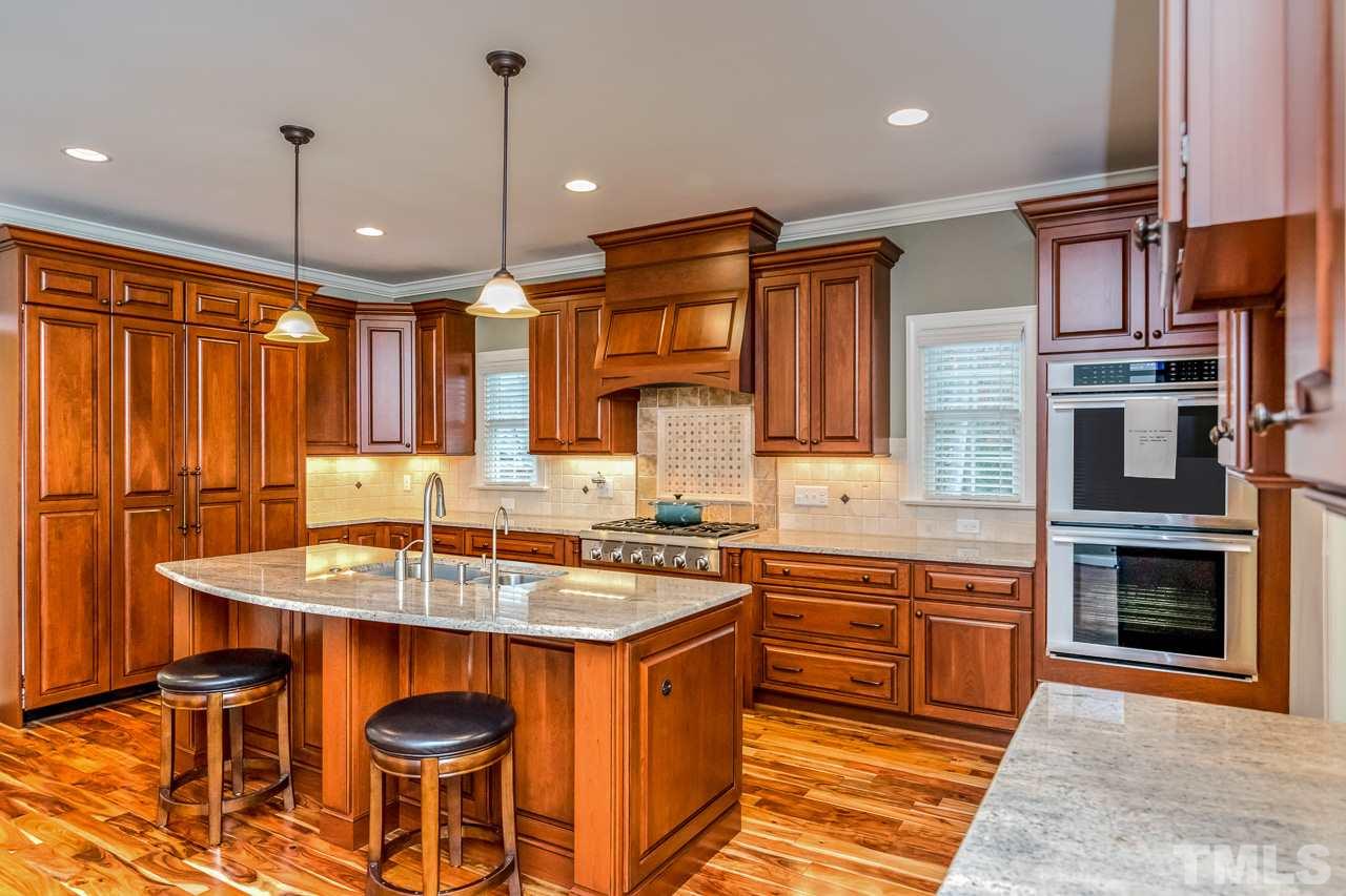 4201 Frost Court Raleigh, NC 27609 - Photo 11 of 25 a kitchen with stainless steel appliances granite countertop a sink stove and refrigerator