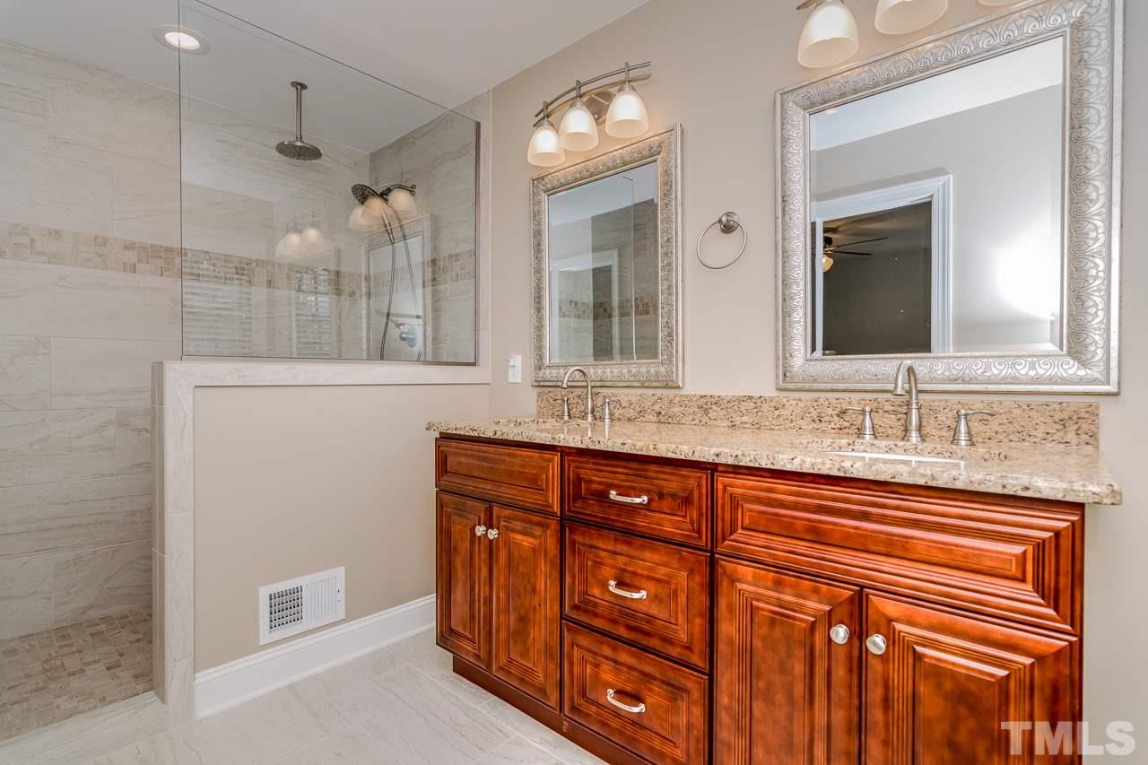 4201 Frost Court Raleigh, NC 27609 - Photo 17 of 25 a bathroom with a granite countertop sink and a mirror