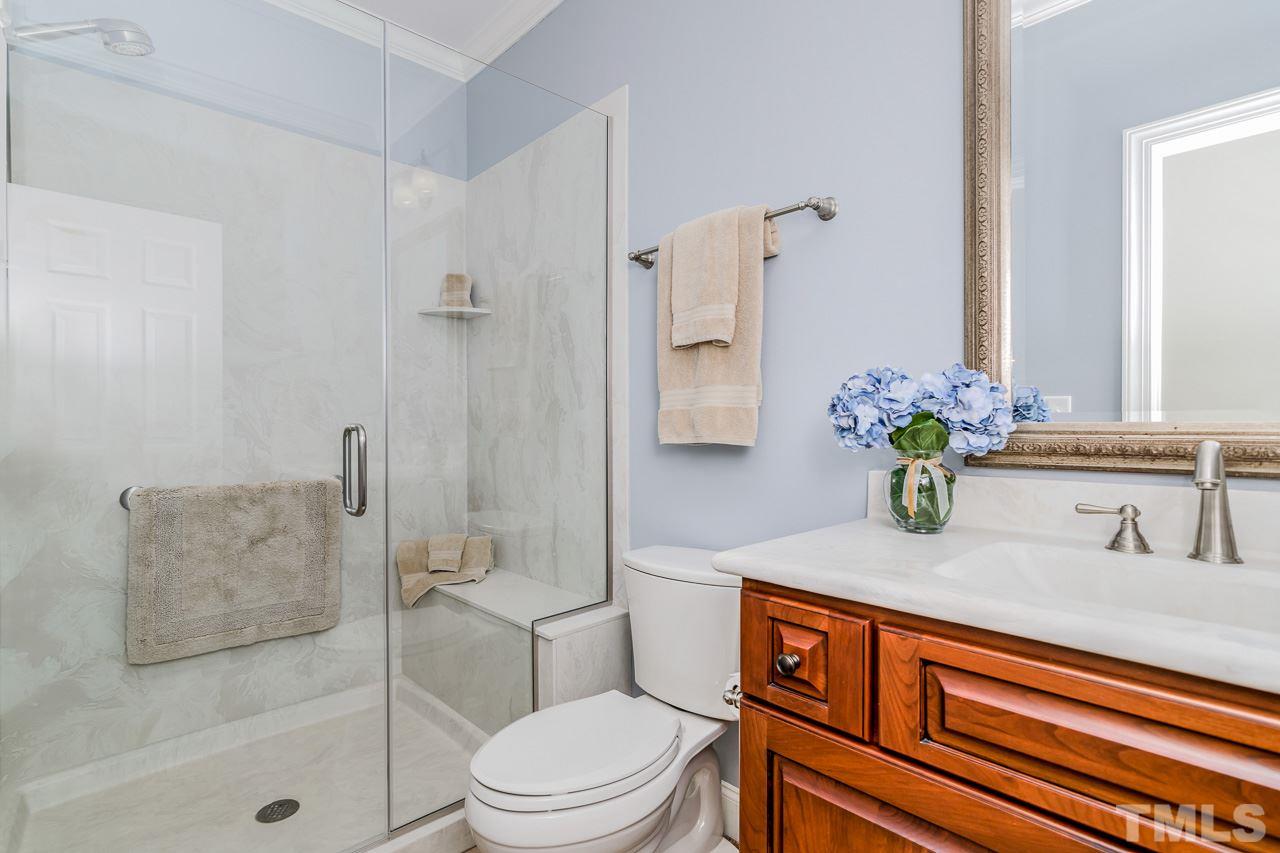 4201 Frost Court Raleigh, NC 27609 - Photo 21 of 25 a bathroom with a granite countertop sink a toilet and shower