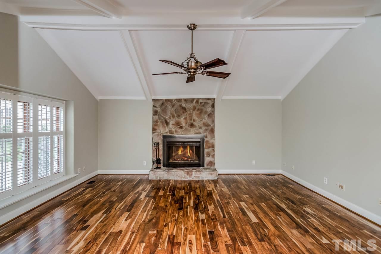 4201 Frost Court Raleigh, NC 27609 - Photo 24 of 25 a view of empty room with a fireplace and wooden floor
