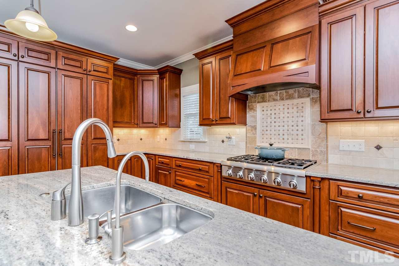 4201 Frost Court Raleigh, NC 27609 - Photo 10 of 25 a kitchen with stainless steel appliances granite countertop a sink stove and cabinets