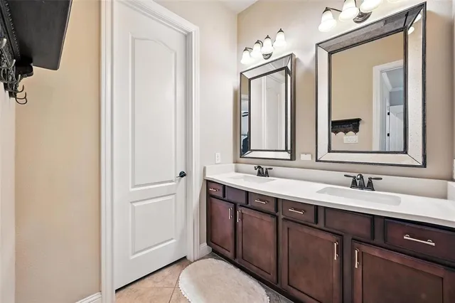 a bathroom with a double vanity sink a mirror and a bathtub
