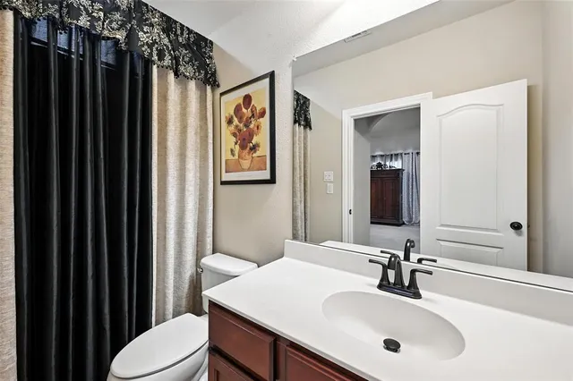 a bathroom with a sink mirror and toilet