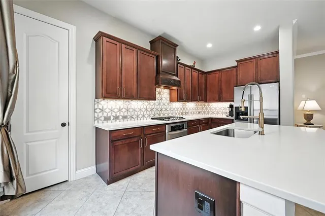a kitchen with stainless steel appliances kitchen island granite countertop a sink stove and refrigerator