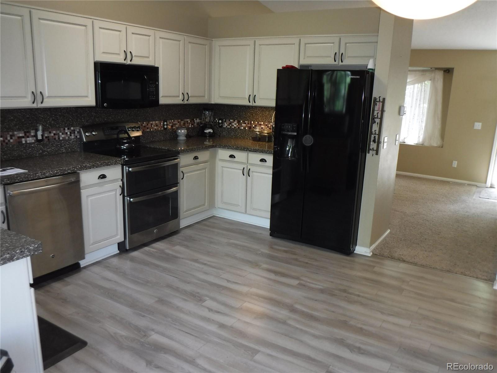 1149 Timbervale Trail Highlands Ranch, CO 80129 - Photo 14 of 32 a kitchen with stainless steel appliances granite countertop a refrigerator stove and sink