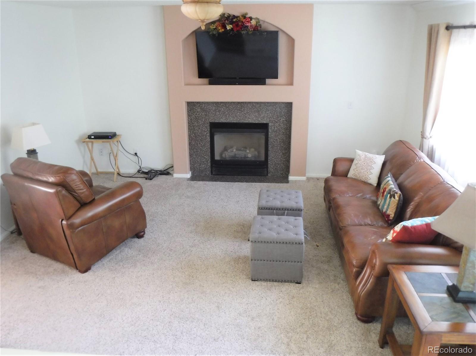 1149 Timbervale Trail Highlands Ranch, CO 80129 - Photo 16 of 32 a living room with furniture and a fireplace