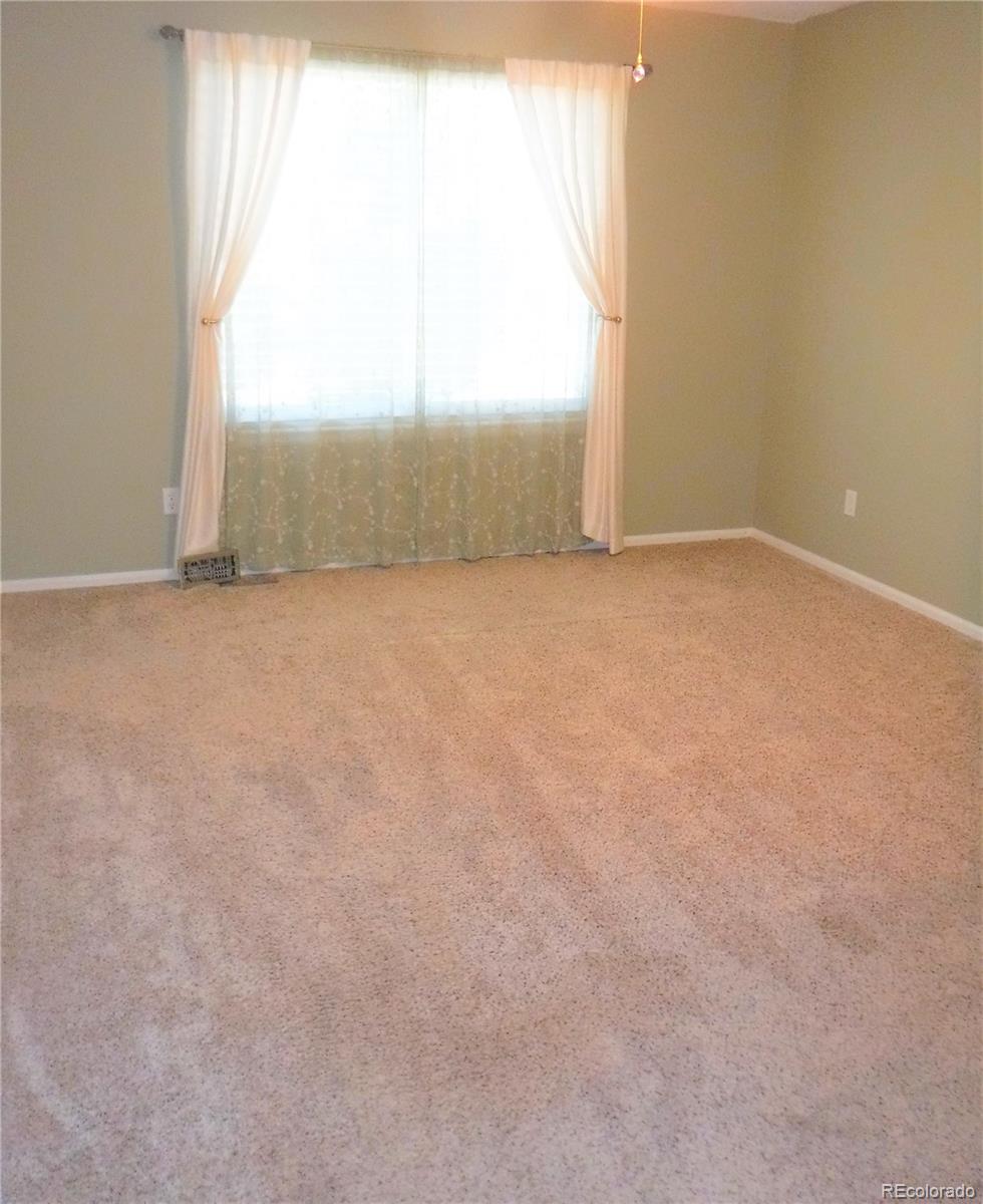 1149 Timbervale Trail Highlands Ranch, CO 80129 - Photo 20 of 32 an empty room with wooden floor and windows