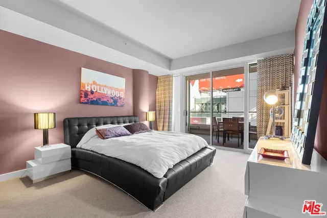 a bedroom with a bed and large windows