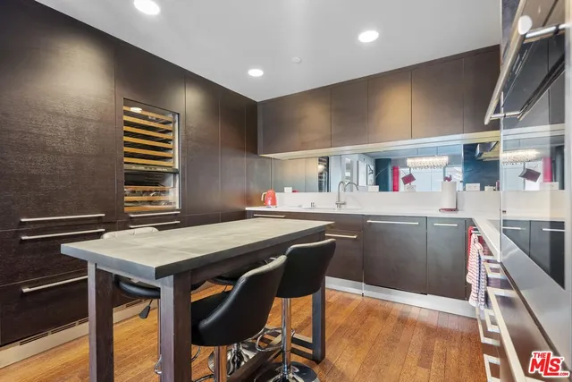 a kitchen with stainless steel appliances cabinets and wooden floor