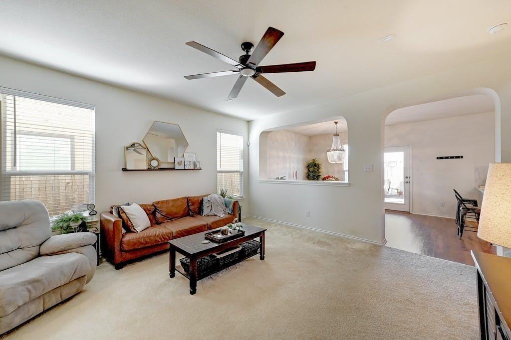13916 Inaugural Street Manor, TX 78653 - Photo 8 of 28 A welcoming living room featuring a subtle pass-through window to an adjacent space.