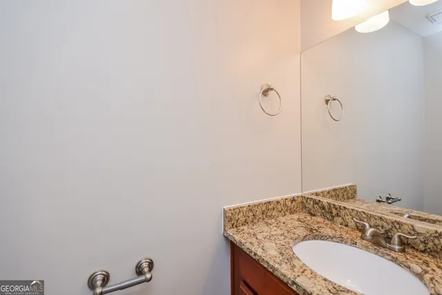 a bathroom with a granite countertop sink and mirror