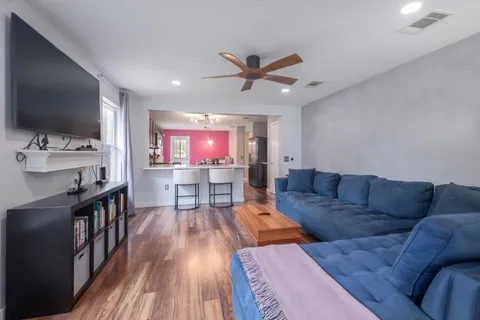 a living room with furniture and a wooden floor
