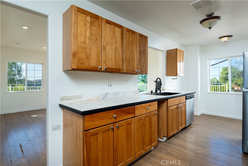 10161 Foothill Boulevard Sylmar, CA 91342 - Photo 12 of 65 a kitchen with stainless steel appliances granite countertop wooden cabinets a sink and a hard wood floors