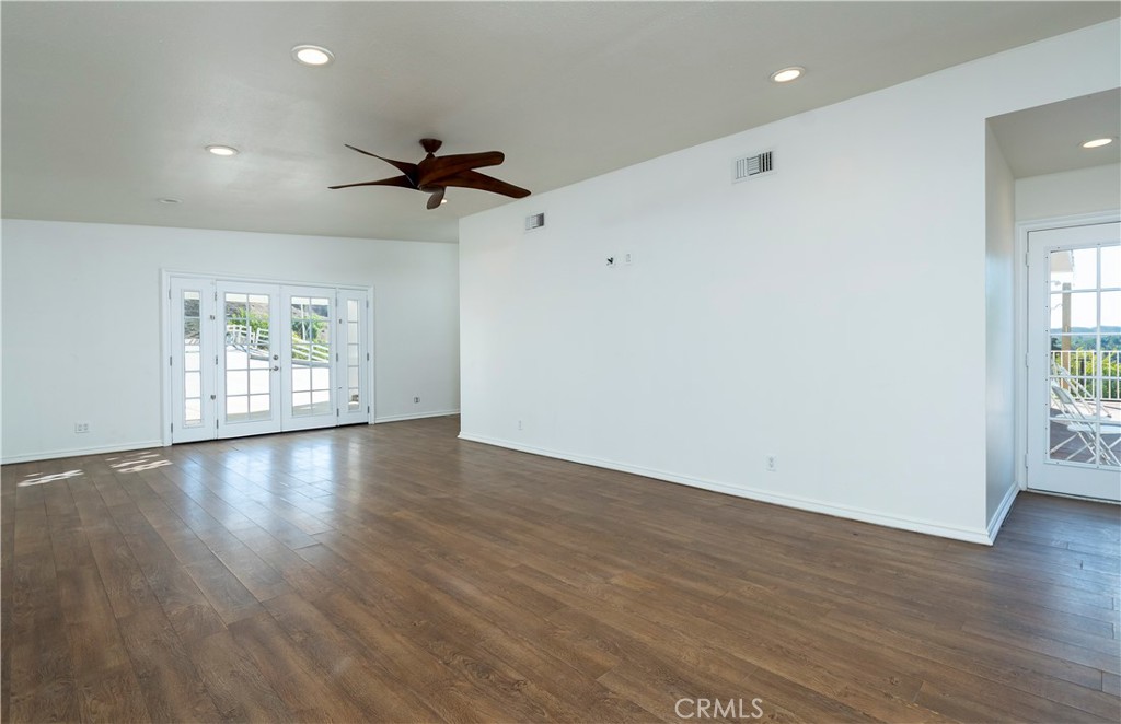 10161 Foothill Boulevard Sylmar, CA 91342 - Photo 15 of 65 an empty room with wooden floor ceiling fan and windows
