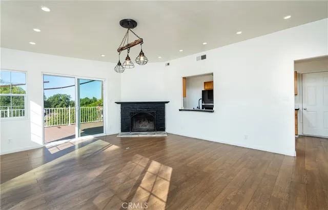 a kitchen with stainless steel appliances granite countertop wooden cabinets a stove a sink and dishwasher with wooden floor