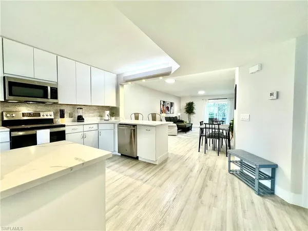 a kitchen with white cabinets and stainless steel appliances