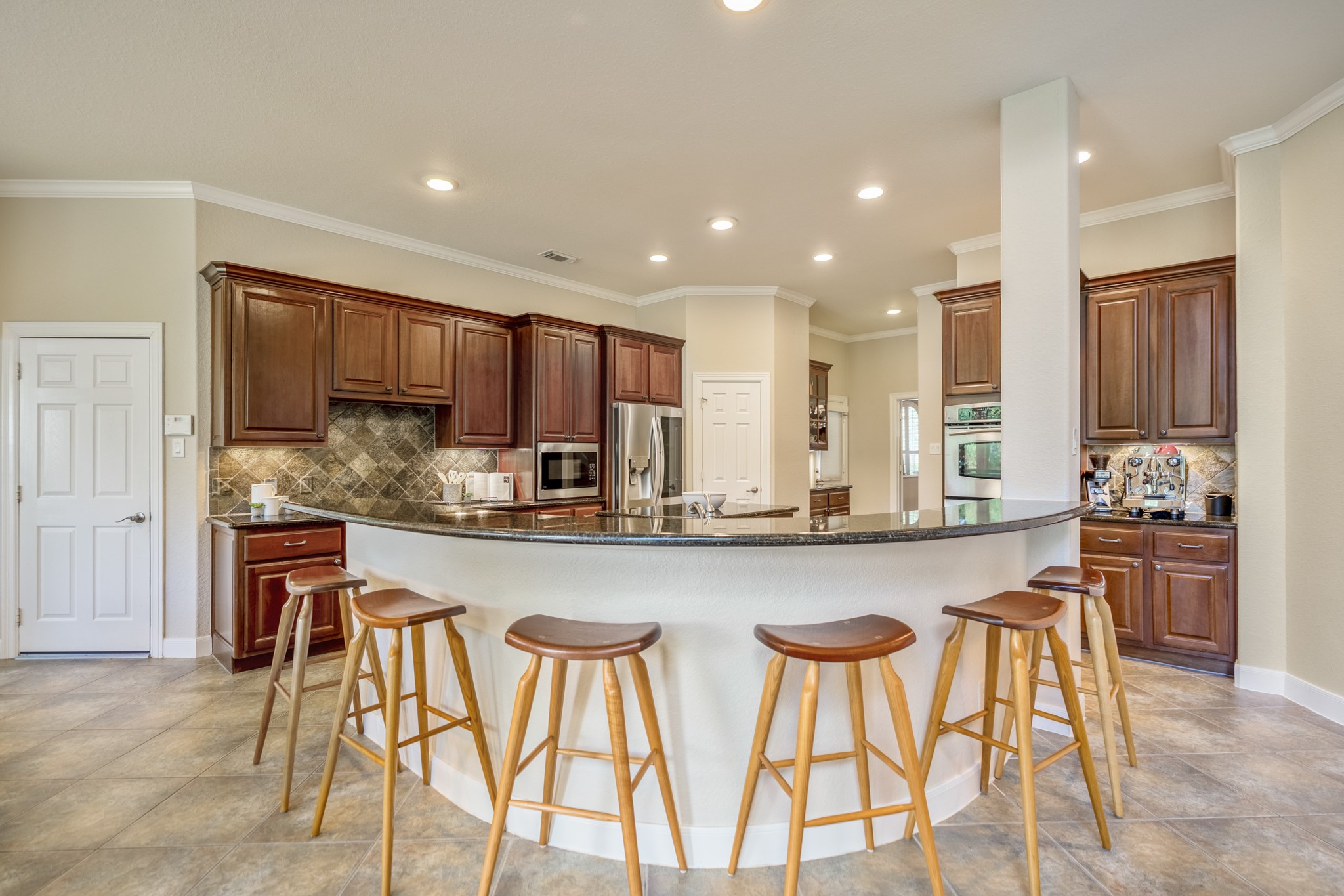 67 North Pentenwell Circle Spring, TX 77382 - Photo 11 of 50 a kitchen with stainless steel appliances granite countertop table chairs sink and stove