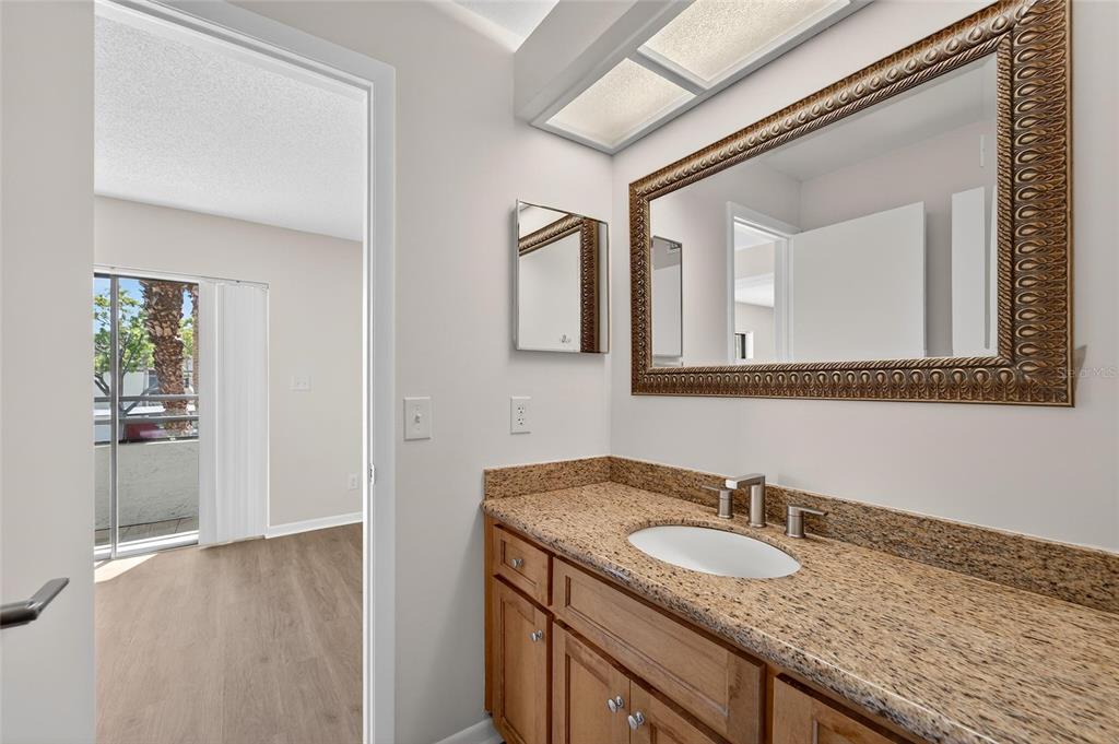 13610 South Village Drive, Unit 4209 Tampa, FL 33618 - Photo 16 of 54 a bathroom with a granite countertop sink and a mirror