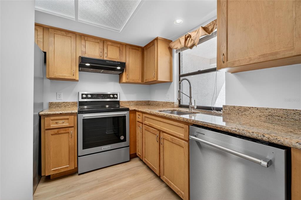 13610 South Village Drive, Unit 4209 Tampa, FL 33618 - Photo 21 of 54 a kitchen with stainless steel appliances granite countertop a stove a sink and a microwave