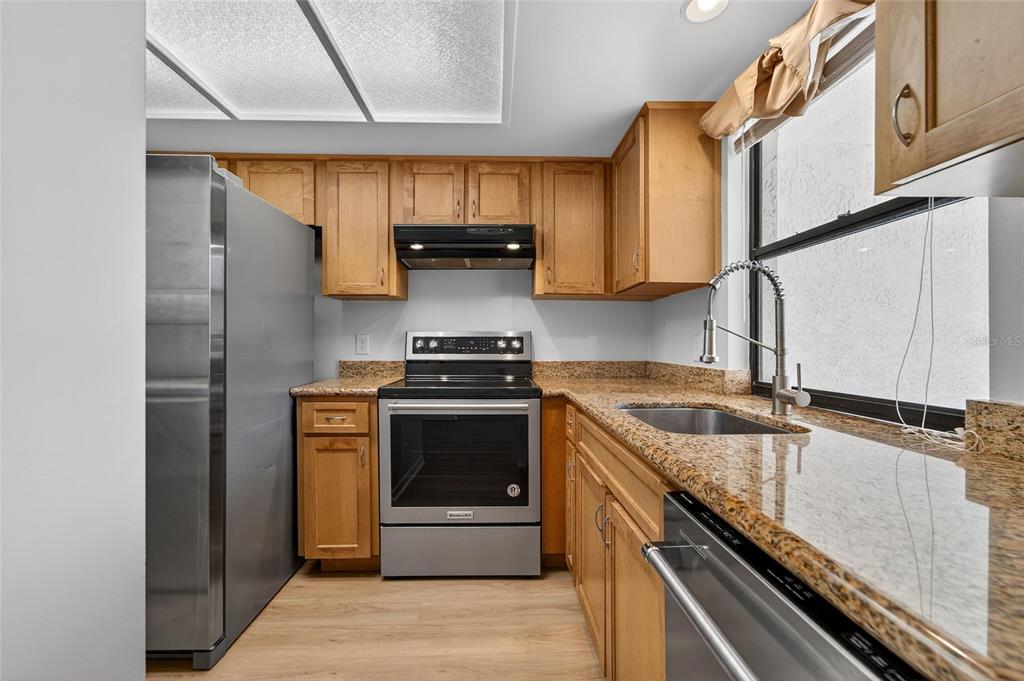 13610 South Village Drive, Unit 4209 Tampa, FL 33618 - Photo 22 of 54 a kitchen with stainless steel appliances granite countertop a sink a stove and a refrigerator