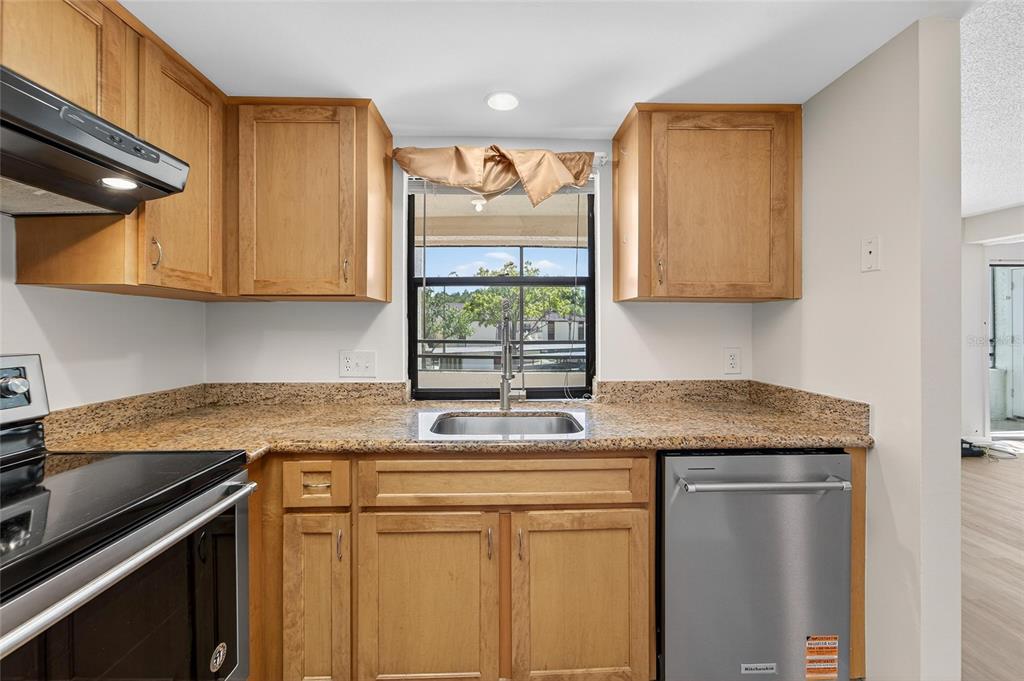 13610 South Village Drive, Unit 4209 Tampa, FL 33618 - Photo 23 of 54 a kitchen with stainless steel appliances granite countertop a sink stove and cabinets