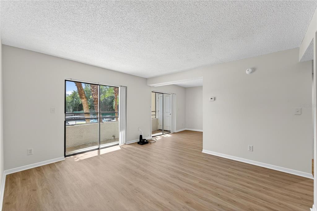 13610 South Village Drive, Unit 4209 Tampa, FL 33618 - Photo 6 of 54 an empty room with wooden floor and windows