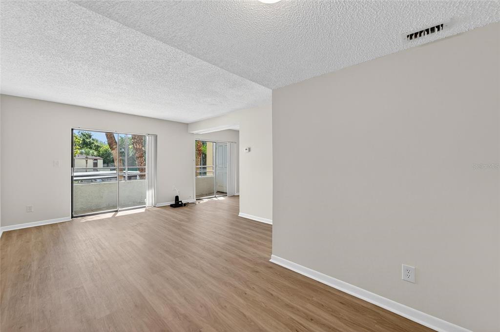 13610 South Village Drive, Unit 4209 Tampa, FL 33618 - Photo 9 of 54 an empty room with wooden floor and windows