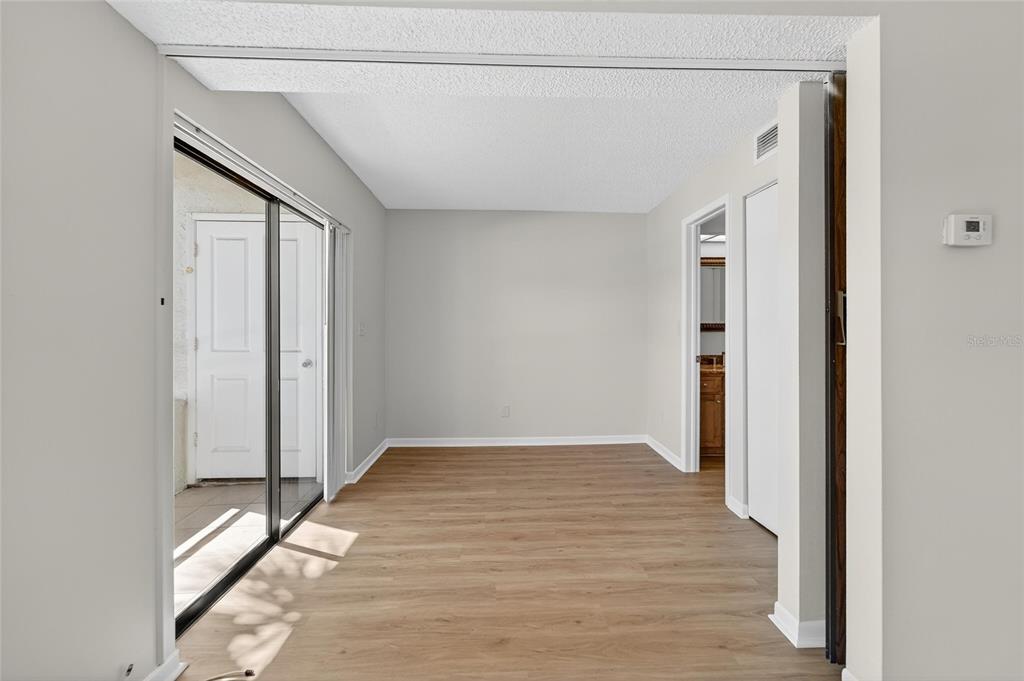 13610 South Village Drive, Unit 4209 Tampa, FL 33618 - Photo 10 of 54 a view of an empty room with wooden floor and a window