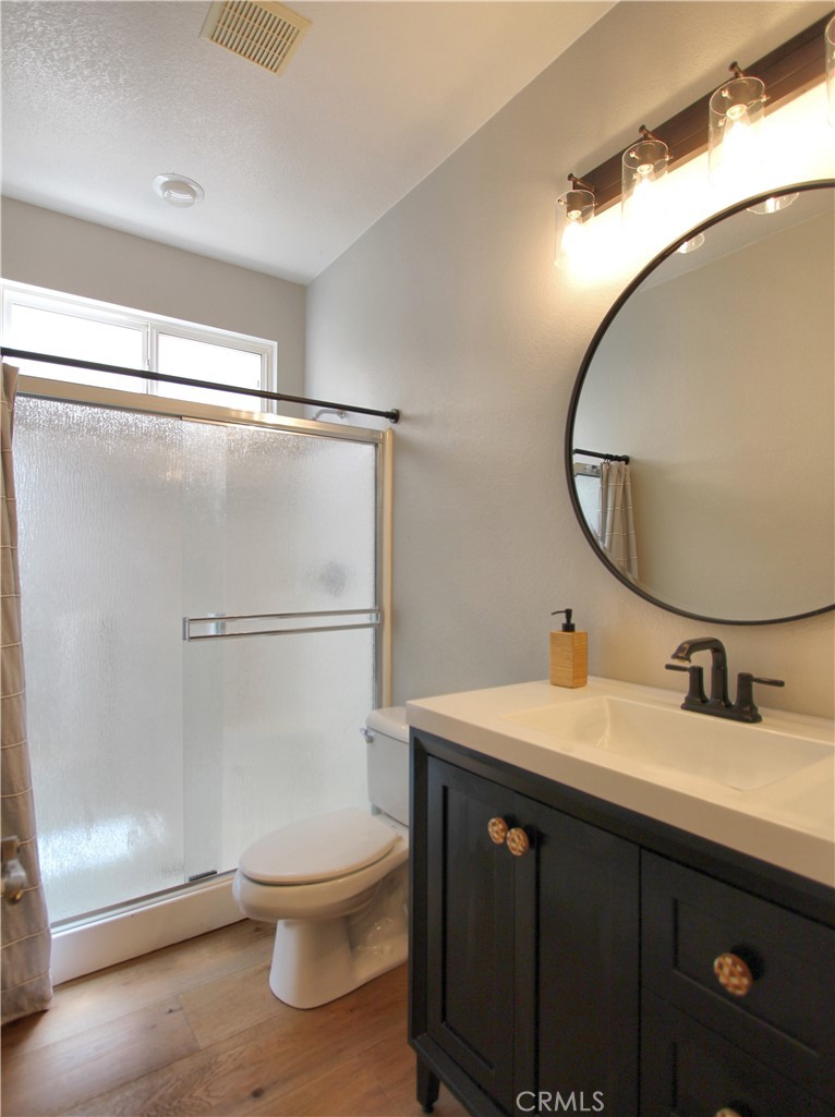1442 Midnight Sun Drive Beaumont, CA 92223 - Photo 22 of 46 a bathroom with a sink a mirror a toilet and a shower