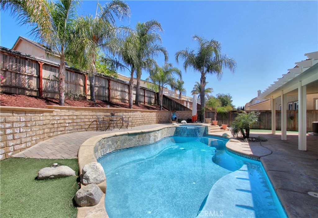 1442 Midnight Sun Drive Beaumont, CA 92223 - Photo 41 of 46 a view of a swimming pool with lawn chairs under an umbrella